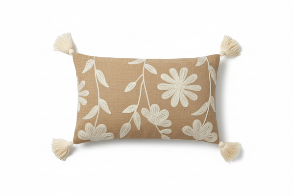 Sandy beige daisy floral lumbar cushion cover with corner tassels — flat lay on white background