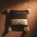 Dark chocolate and cream bobble weave cushion cover against warm terracotta wall, artisan beauty shot